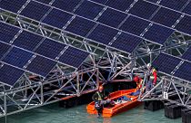 Workers assemble floating barges with solar panels on the 'Lac des Toules', an alpine reservoir lake, in Bourg-Saint-Pierre, Switzerland, 8 October 2019.