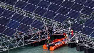Workers assemble floating barges with solar panels on the 'Lac des Toules', an alpine reservoir lake, in Bourg-Saint-Pierre, Switzerland, 8 October 2019. 