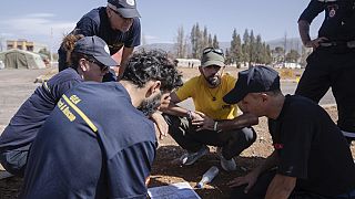 Equipas de emergência marroquina e espanhola discutem plano de resgate em campo militar na cidade de Amizmiz, perto de Marraquexe, Marrocos