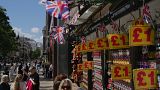 People walk along a street in a shopping district in central London, Tuesday, Aug. 22, 2023.