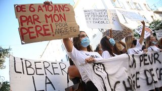 Women hold banners reading 'Unleash the words' and 'From 6 to 10 by my father' during an anti-abuse demonstration in Corsica.