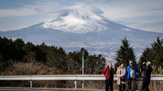 People having their photographs taken in front of Japan's Mount Fuji