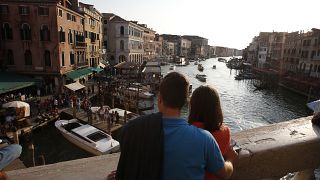 Los turistas disfrutan de la vista desde el puente de Rialto en Venecia, Italia, jueves 25 de septiembre de 2014.