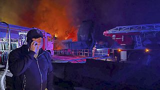 Sivastopol Valisi Mikhail Razvozhaev, Kırım'da yanan Sivastopol Tersanesi'nden duman ve alevler yükselirken cep telefonuyla konuşuyor. 