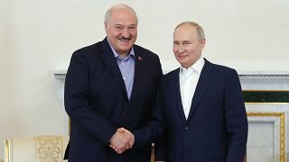 Aljakszandr Lukasenka belarusz elnök (balra) és Vlagyimir Putyin orosz elnök kezet fognak szentpétervári találkozójukon 2023. július 23-án.