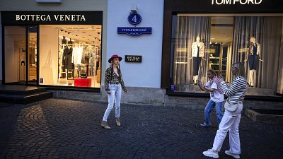 FILE - A Moscow fashionista poses in a street of expensive boutiques not far from Red Square in Moscow, Russia, Monday, Aug. 21, 2023.