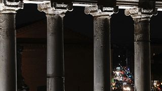 Motorists are framed by the columns of the Temple of Saturn of the Roman Forum, in Rome, Tuesday, 13 December 2022.