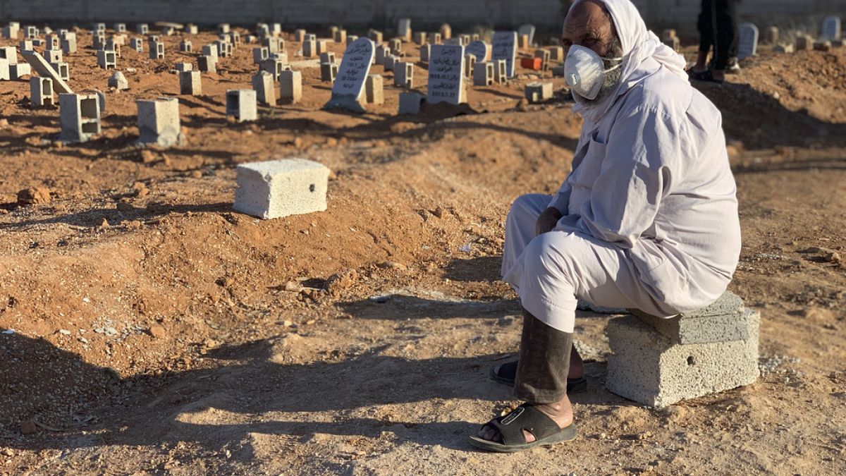 A man sits by the graves of the flash flood victims in Derna, Libya, Friday, Sept. 15, 2023