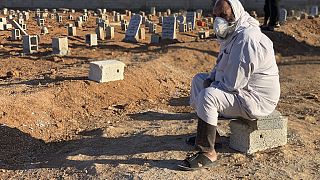 A man sits by the graves of the flash flood victims in Derna, Libya, Friday, Sept. 15, 2023