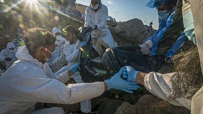 Vítima mortal das inundações na Líbia é recolhiada pelas autoridades, Derna, Líbia