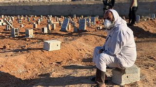 مردی در کنار قبر قربانیان سیل در درنه، لیبی