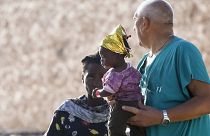 Um bebé migrante é segurado por um médico depois de desembarcar no porto da ilha siciliana de Lampedusa, no sul de Itália, no sábado, 16 de setembro de 2023.