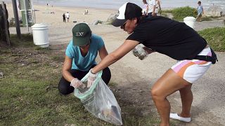 Voluntários recolhem lixo perto da praia em Bidart, no sudoeste de França, no sábado, 16 de setembro de 2023.