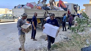 People deliver donated aid to a flash flood-destroyed city of Derna, Libya, Saturday, Sept. 16, 2023. 