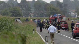 Destroços de um carro queimado enquanto os bombeiros isolam a área onde um avião da equipa acrobática Frecce Tricolori se despenhou perto de Turim, a 16 de setembro de 2023
