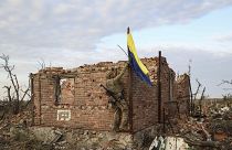 Офицер ВСУ поднимает украинский флаг над Андреевкой в Донецкой области. 16 сентября 2023.