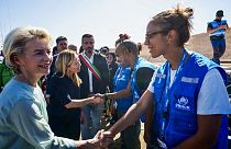 Глава  Еврокомиссии Урсула фон дер Ляйен и премьер-министр Италии Джорджа Мелони приветствуют сотрудников УВКБ ООН на Лампедузе 