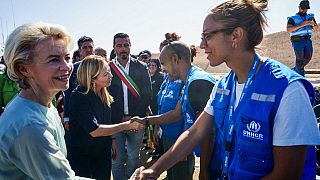Глава  Еврокомиссии Урсула фон дер Ляйен и премьер-министр Италии Джорджа Мелони приветствуют сотрудников УВКБ ООН на Лампедузе