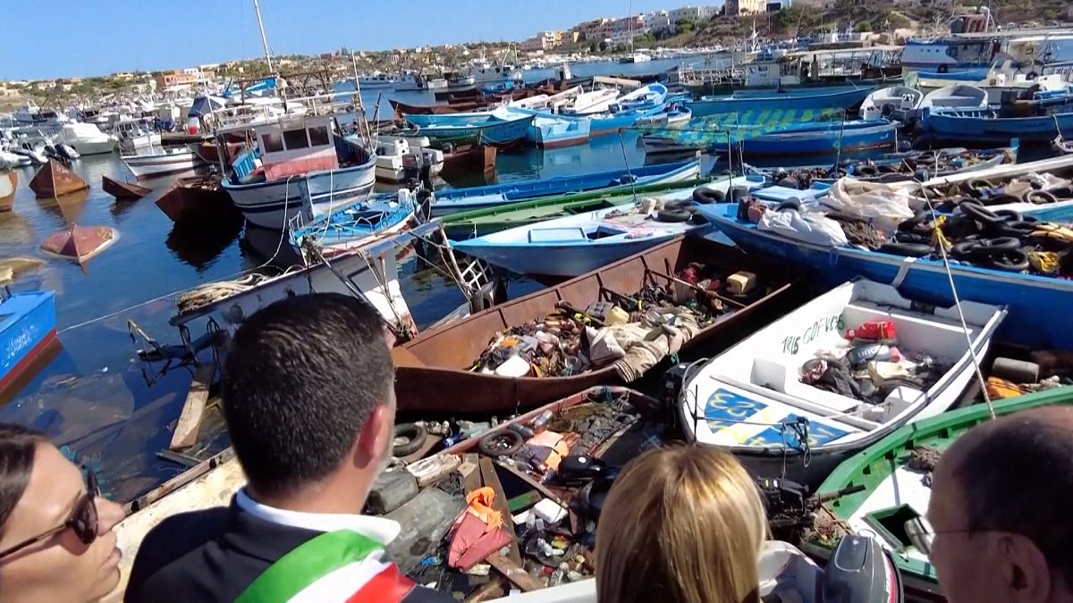 La primera ministra de Italia, Giorgia Meloni, contempla pateras vacías en el puerto de Lampedusa.