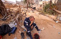 Membro de uma equipa de resgate entre os escombros em Derna.