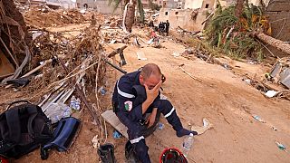Membro de uma equipa de resgate entre os escombros em Derna.
