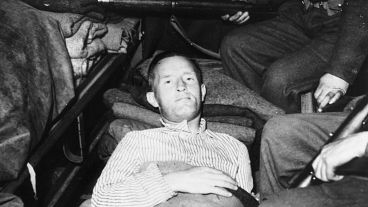 William Joyce - or Lord Haw Haw - pictured surrounded by armed guards as he arrives on a stretcher at a hospital near Luneberg, Germany