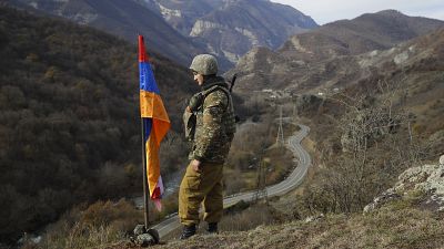 Un soldat d'origine arménienne à côté du drapeau du Haut Karabakh, le 25 novembre 2020.