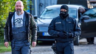 Sven Krueger, left, a right-wing extremist known throughout Germany, is accompanied by a police during search operation on his property in Jamel, Germany, 19 September 2023