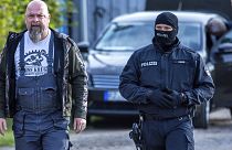 Rendőr kíséri el Sven Krueger neonáci aktivistát a házkutatása idején
