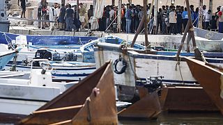 Migrants stand on the dock of the port of the Sicilian island of Lampedusa, southern Italy, Monday, Sept. 18, 2023