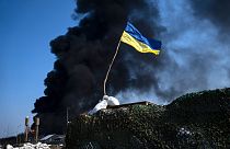 علم أوكرانيا وتصاعد الدخان على مشارف كييف، أوكرانيا.