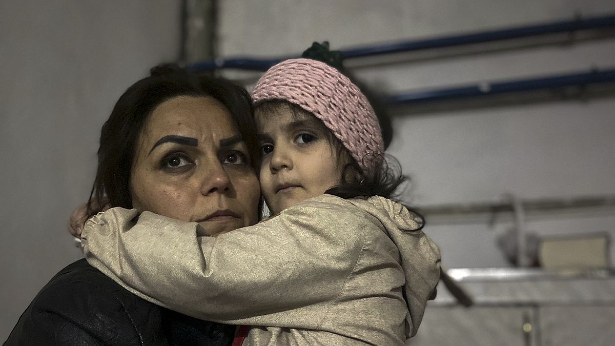 Menina abraça familiar sentada num abrigo durante um bombardeamento em Stepanakert, em Nagorno-Karabakh.