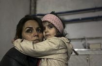 Menina abraça familiar sentada num abrigo durante um bombardeamento em Stepanakert, em Nagorno-Karabakh.