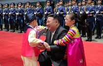 طفلان يعانقان زعيم كوريا الشمالية كيم جونغ أون في محطة قطارات بيونغ يانغ بعد عودته من زيارة إلى روسيا