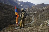 Soldado junto a una bandera de Armenia