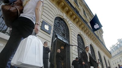 People leave the Apple store in Paris Friday, March 16, 2012.