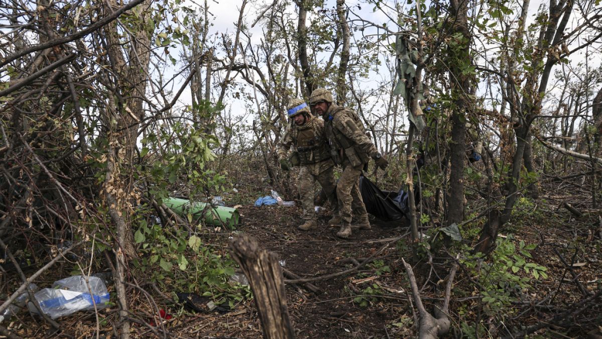 Halott katonát visznek társai az ukrán fronton