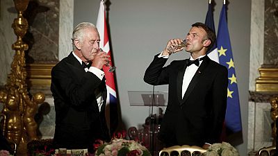 French President Emmanuel Macron, right, and Britain's King Charles III toast during a state dinner in the Hall of Mirrors at the Chateau de Versailles in Versailles.