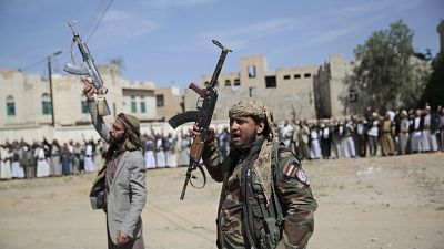 مقاتلون حوثيون مسلحون يحضرون موكب تشييع