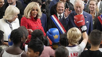 كاميلا وبريجيت ماكرون وملك بريطانيا تشارلز الثالث يتحدثون مع أطفال يمارسون الملاكمة خلال زيارة إلى صالة للألعاب الرياضية، سان دوني شمال باريس 21 أيلول 2023