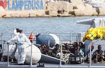 Des migrants attendent sur un navire avant de débarquer sur l'île de Lampedusa