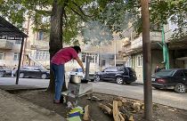 امرأة تطبخ على موقد مؤقت في ساحة في ستيباناكيرت، ناغورنو كاراباخ. 2023/09/21