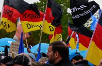 Protesters hold German flags with "We are the people" written on them during a rally of far-right groups in Berlin.