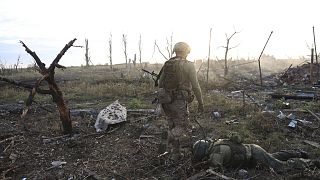Ukrán parancsnok egy orosz katona holtteste mellett a donyecki Andrijivkánál