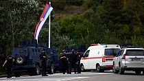 Kosovo's police officers stand guard at the entrance of the village of Banjska on Sunday, after one policeman was killed and another wounded i