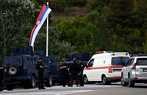Kosovo's police officers stand guard at the entrance of the village of Banjska on Sunday, after one policeman was killed and another wounded i
