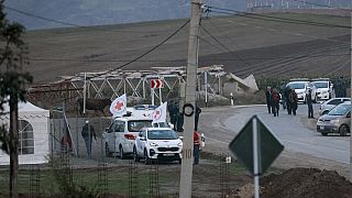 Operarios de la Cruz Roja esperan la llegada de refugiados armenios de Nagorno Karabaj. 