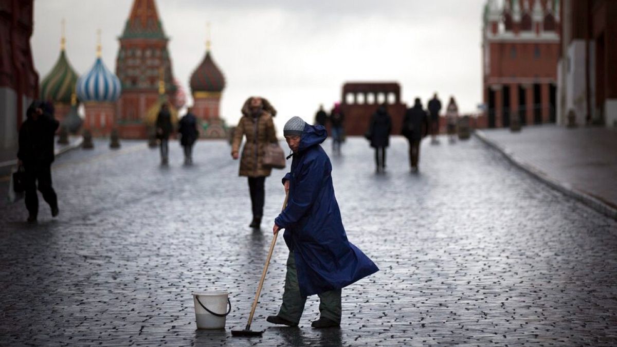 ARQUIVO - Um trabalhador de rua limpa as pedras do pavimento na Praça Vermelha em Moscovo, Rússia, terça-feira, 22 de dezembro de 2015\. 