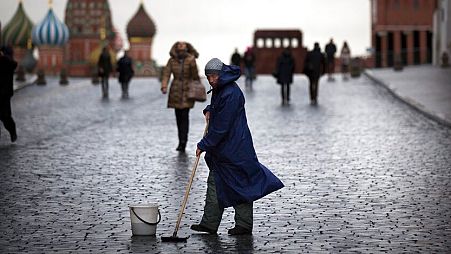 FILE - A street worker cleans paving stones in Red Square in Moscow, Russia, Tuesday, Dec. 22, 2015. 
