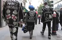 Tracking shot pearly kings and queens marching in Guildhall Yard in London.